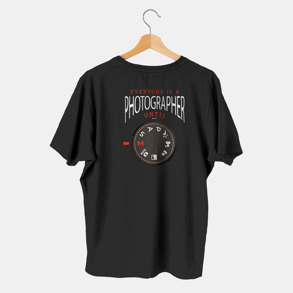 camistea negra con camara de fotos en modo manual con fondo blanco evryone is a photographer